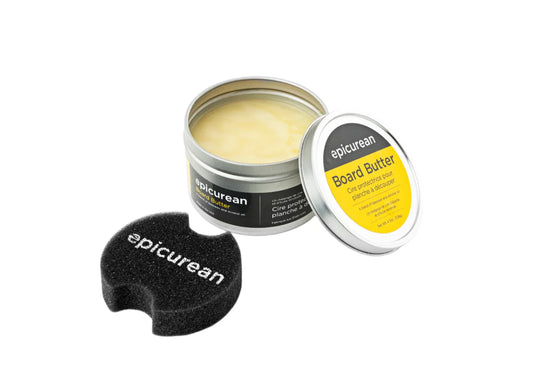 Open tin of Board Butter with a black applicator, labeled 'epicurean' and 'Board Butter'