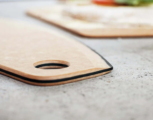 Close-up of a wooden pizza cutter with a black edge on a countertop