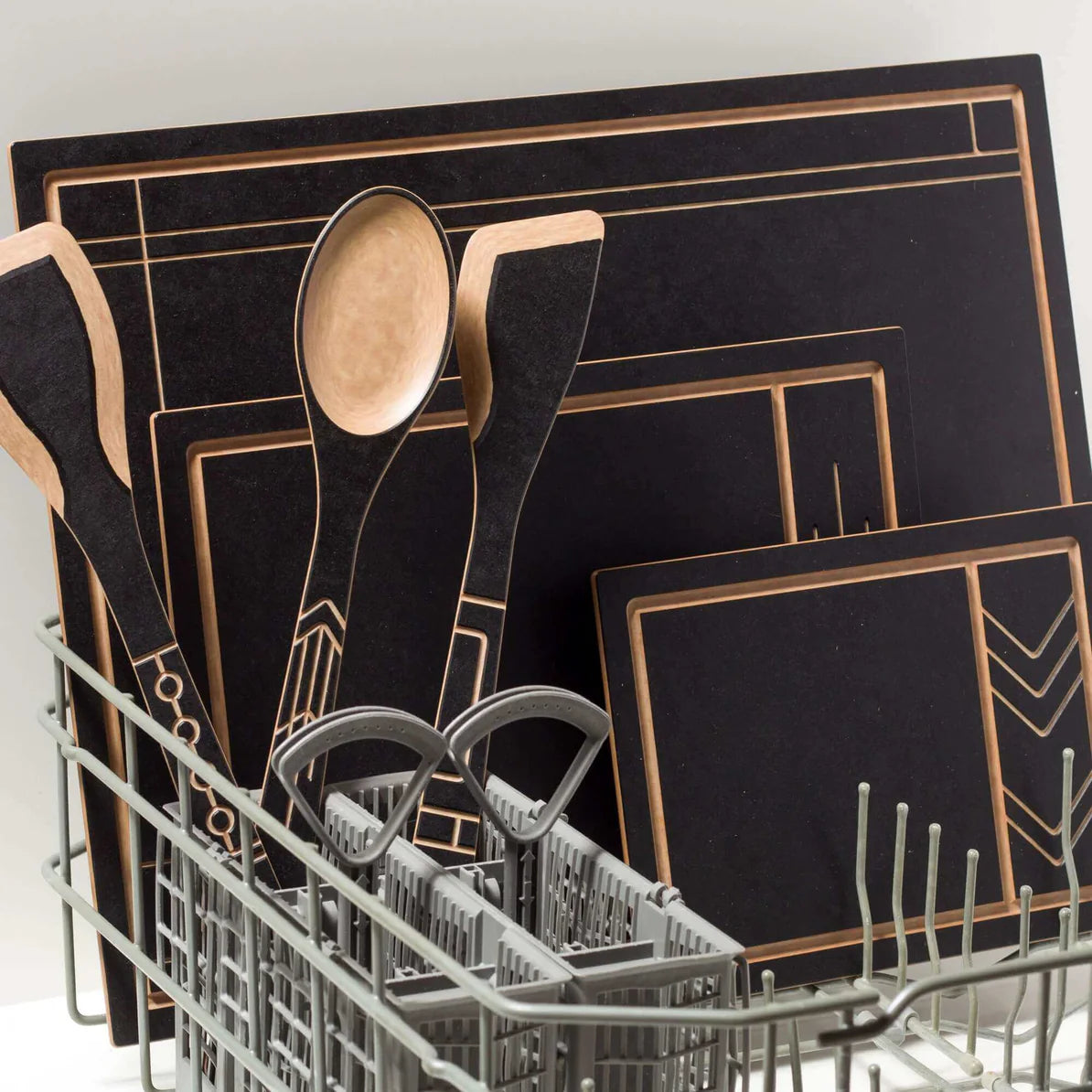 Kitchen utensils and cutting boards in a dishwasher, showcasing their design and functionality.