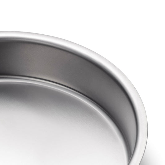 Close-up of a durable 9" round stainless steel cake pan with no handles.