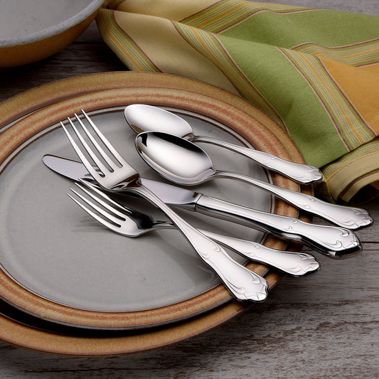 Champlin 45 Piece Set flatware displayed on plates with a napkin