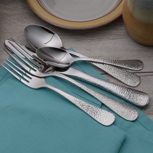Silverware set including forks, spoons, and knives on a table with a teal napkin.