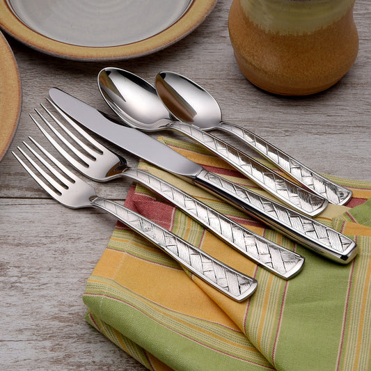 Five pieces of Weave flatware with a basket design on a table setting