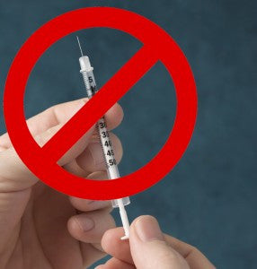 Hand holding a syringe with a red prohibition symbol over it