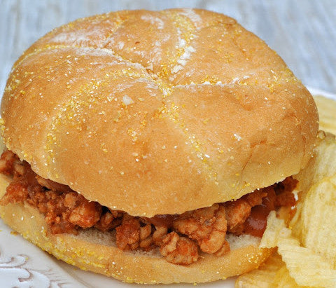 Close-up of a Spoon Burger showcasing saucy ground-meat filling on a seeded bun with potato chips