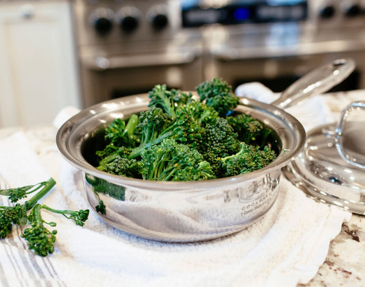 A pot of steamed broccoli on a kitchen counter