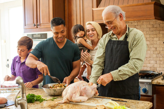 Multigenerational family preparing a turkey in a home kitchen for a holiday meal