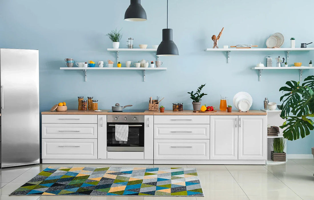 Bright modern kitchen with blue wall, white cabinets, stainless refrigerator, oven, open shelves and geometric rug.