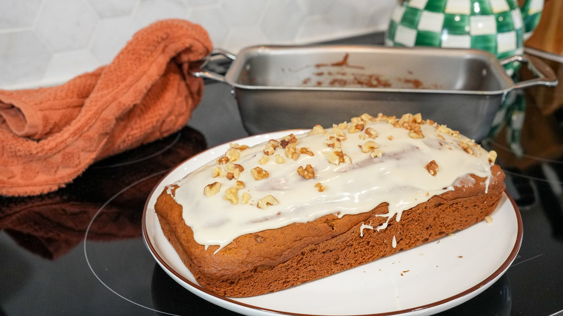 Close-up of pumpkin bread with walnut and maple glaze, topped with chopped walnuts on a plate