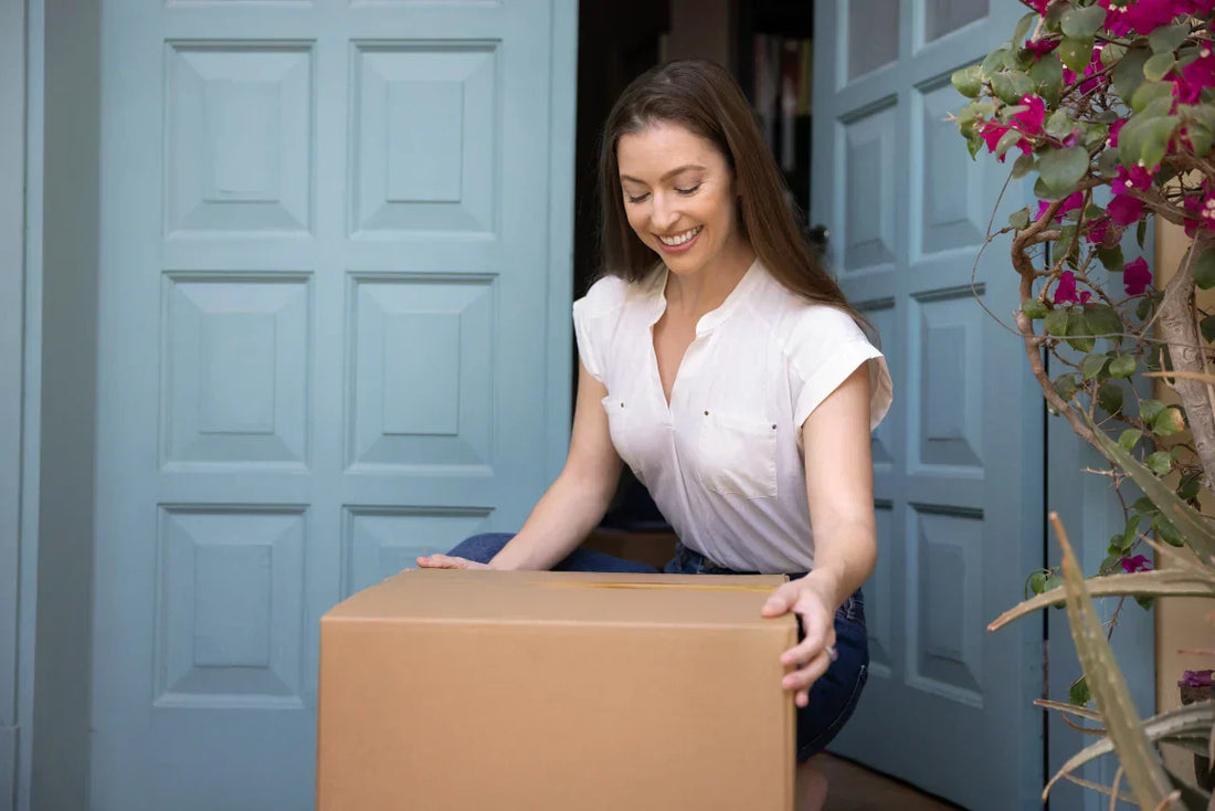 Woman picking up meal kit delivery package from doorstep
