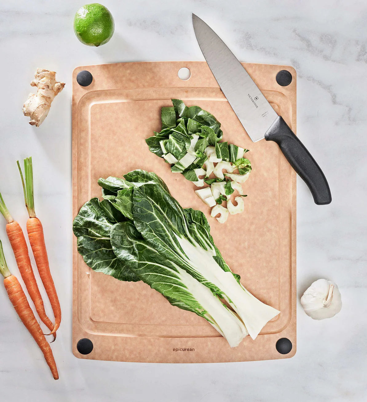 Cutting board with chopped vegetables and a knife on a marble surface