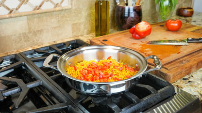 Stovetop with a pan containing diced vegetables on a kitchen counter.