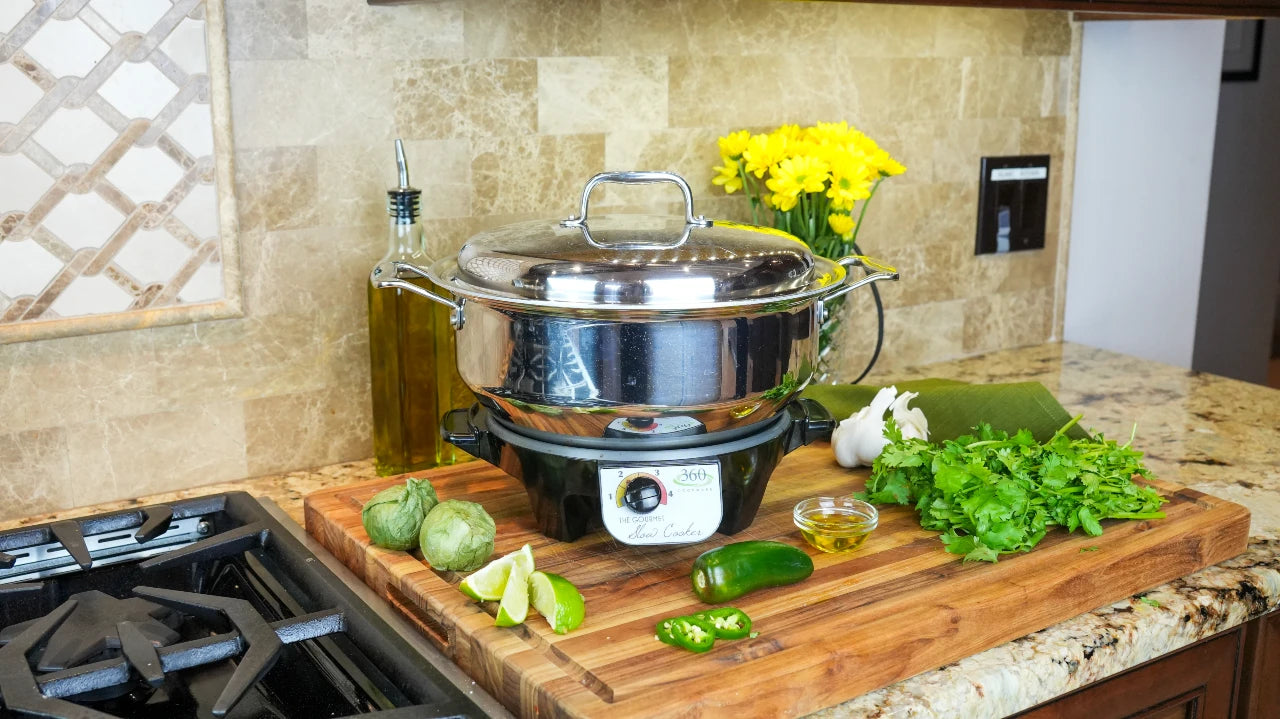 Stainless steel pot on a kitchen counter with vegetables and flowers