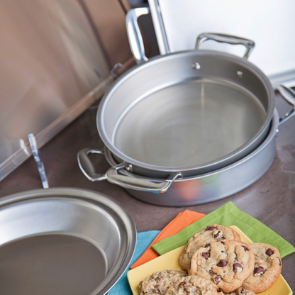 Two round bakeware pans with cookies on a colorful napkin.