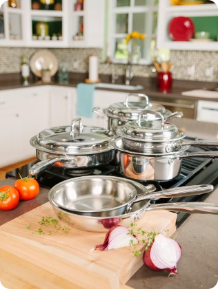 Set of 360 Cookware stainless steel cookware on a kitchen counter with vegetables.
