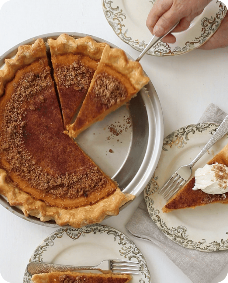 A fork pulling out a slice of Pumpkin pie from pie pan