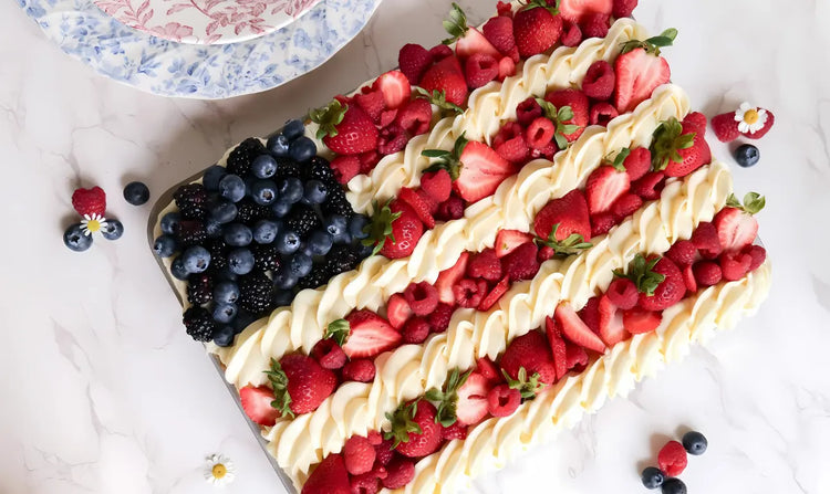Berry-topped dessert shaped like an American flag on a white surface.