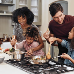 Family of four cooking together in a kitchen