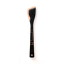 Front view of Frank Lloyd Wright saute tool showing black finish with copper Art Deco accents and angled spatula head on white background