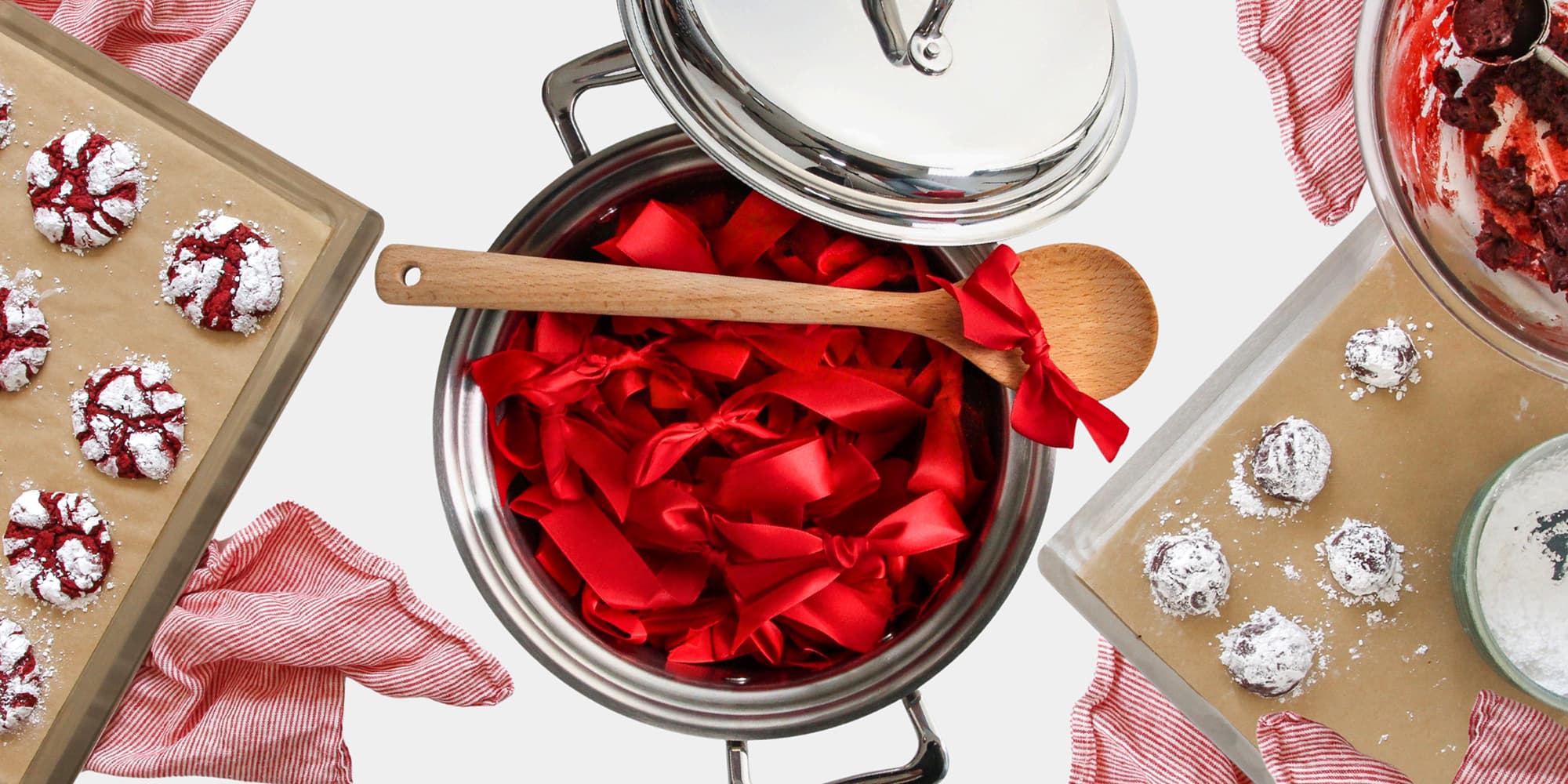 Container of red fabric with a wooden spoon, surrounded by baking trays with cookies.