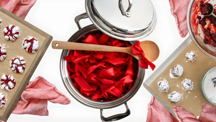 Stovetop with red fabric and wooden spoon, surrounded by baking trays with cookies.