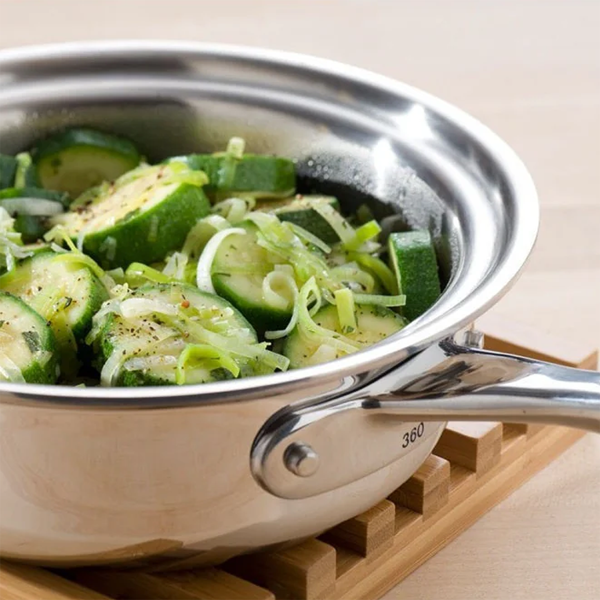 1-quart stainless steel saucepan with cover containing sliced zucchini and leeks, showcasing 360 Vapor® Cooking technology