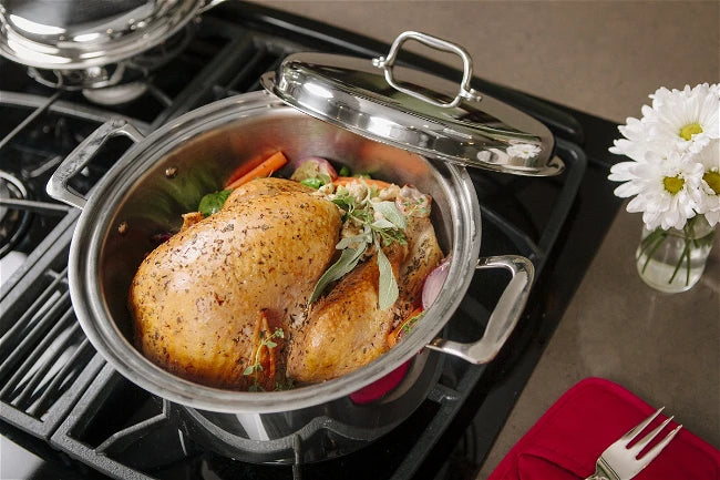 Roasted chicken cooking in a stainless steel pan on a stovetop, illustrating vapor cooking