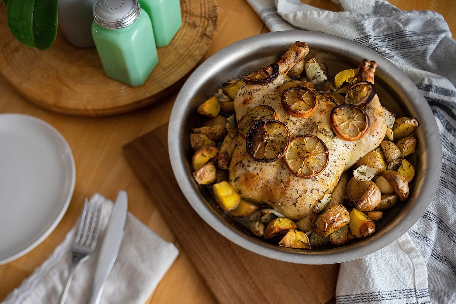 Roasted chicken with lemon and vegetables in a silver baking dish