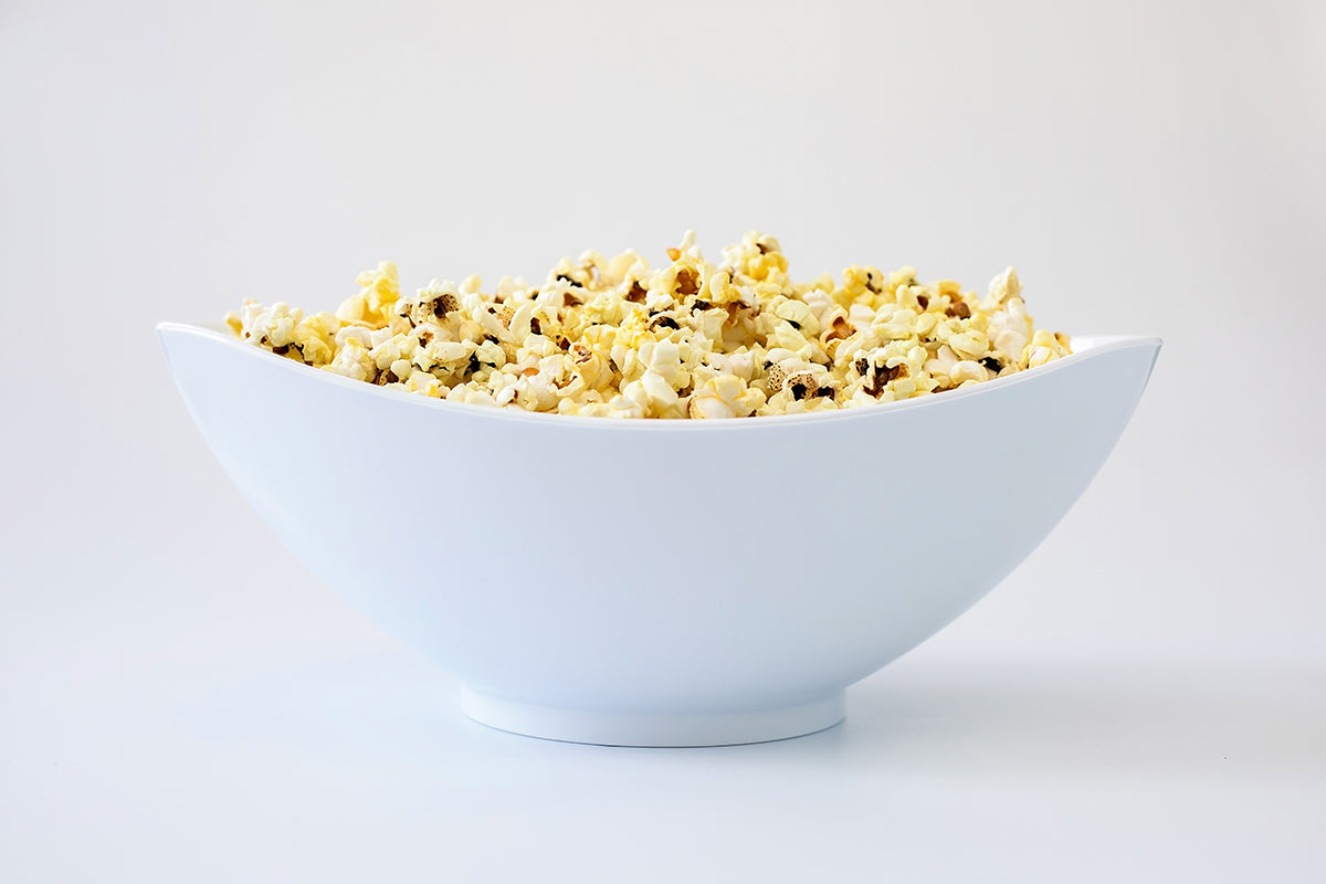 White salad bowl filled with popcorn, showcasing its versatile design.