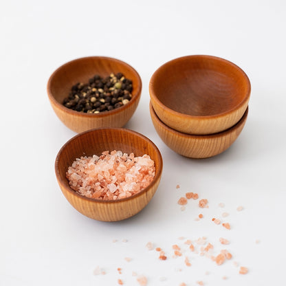 Four handcrafted 2-inch maple condiment cups with pink salt and spices