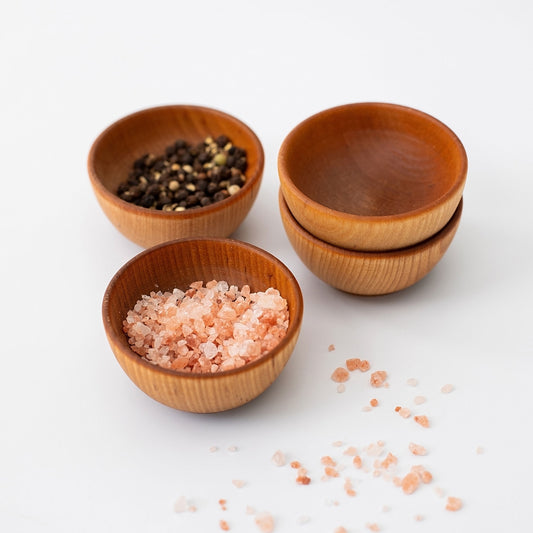 Four handcrafted 2-inch maple condiment cups with pink salt and spices