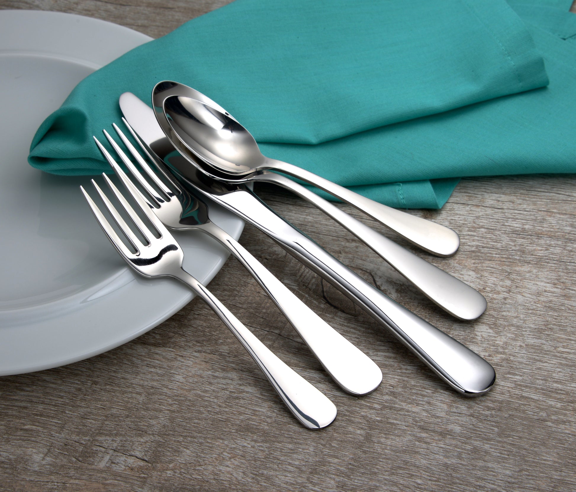 Silverware set including forks, spoons, and knives on a napkin.