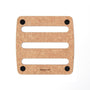 Square epicurean trivet with three horizontal slots and four black non-slip feet, light woodgrain surface.