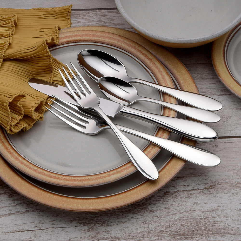 Silverware set on plates with a napkin, showcasing dining arrangement.