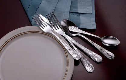 Earth Pattern Flatware set displayed on a table with a plate and napkin.