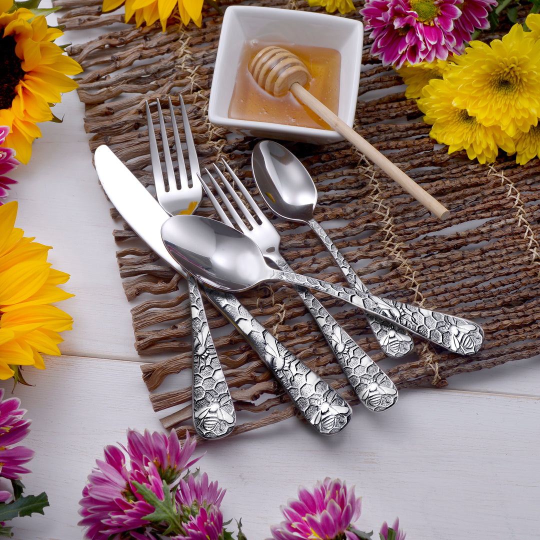 Honey Bee 65 Piece Flatware Set displayed with honey and flowers