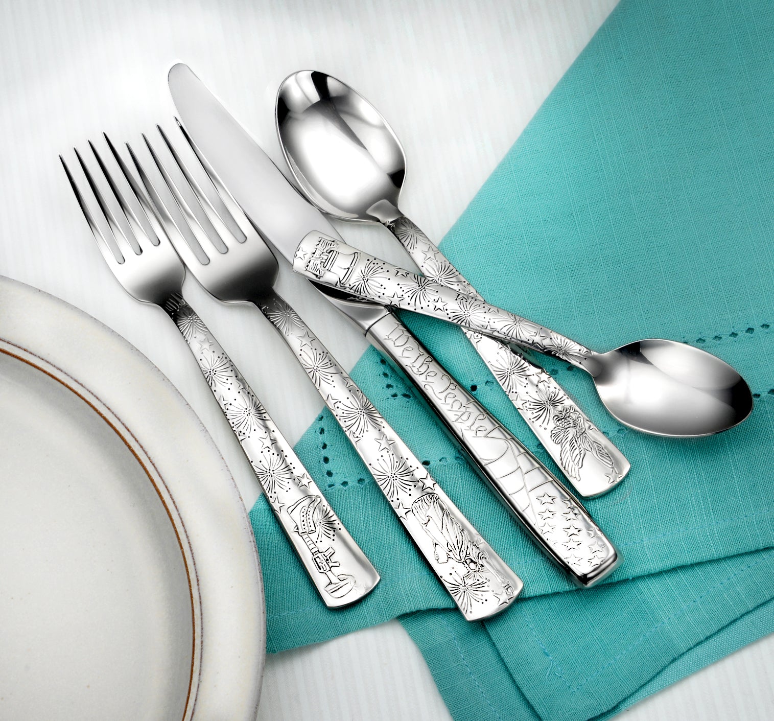 Liberty- 45 Piece Set featuring forks, knives, and spoons on a teal napkin