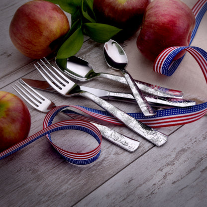 Cutlery set with apples and decorative ribbons on a wooden surface