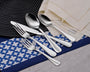Top view of Patriot five-piece flatware showing mirror-polished teardrop handles and American-sized forks on a blue placemat