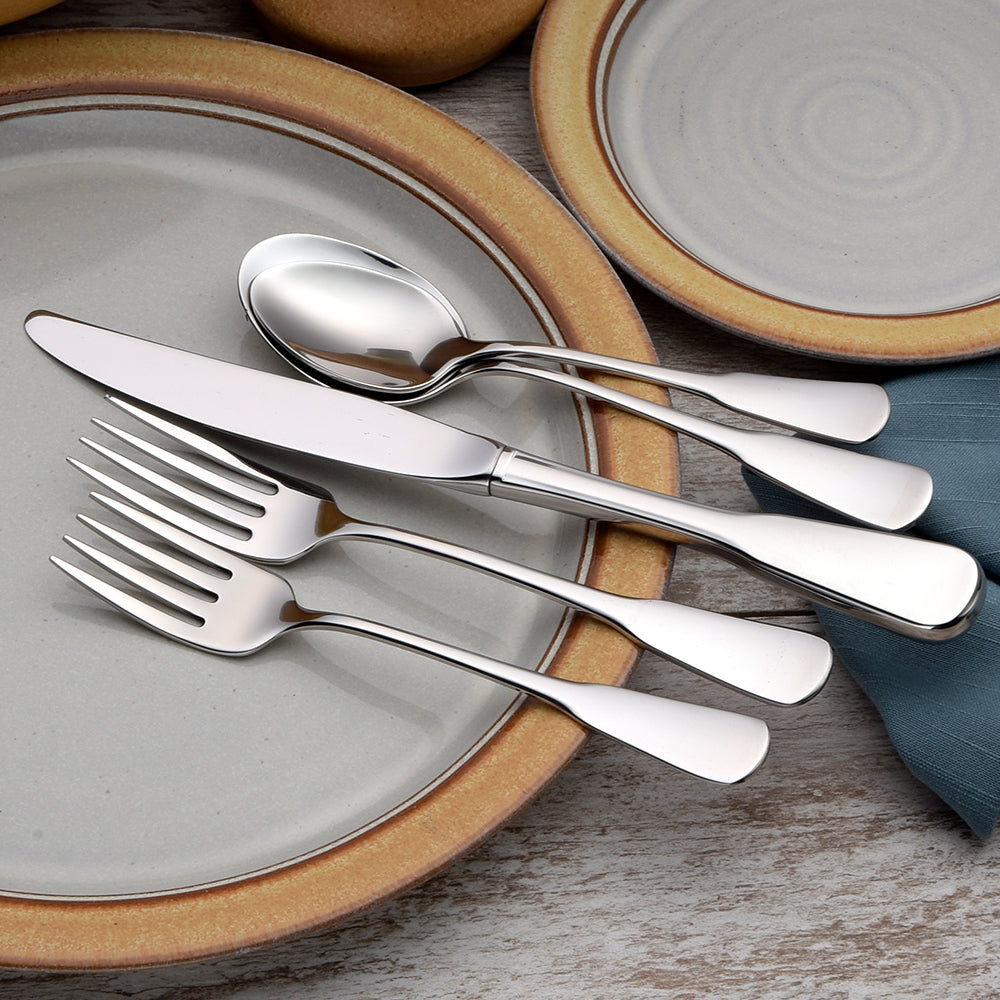 A set of Susanna flatware including a knife, spoon, and forks arranged on a plate.
