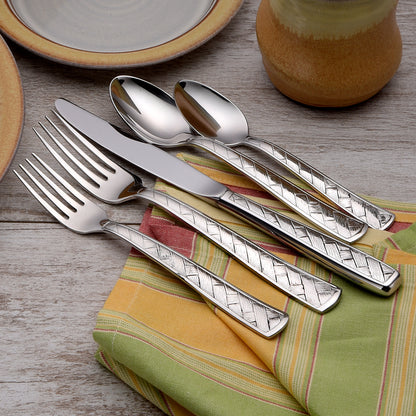 A set of utensils including forks, knives, and spoons with decorative handles on a table.